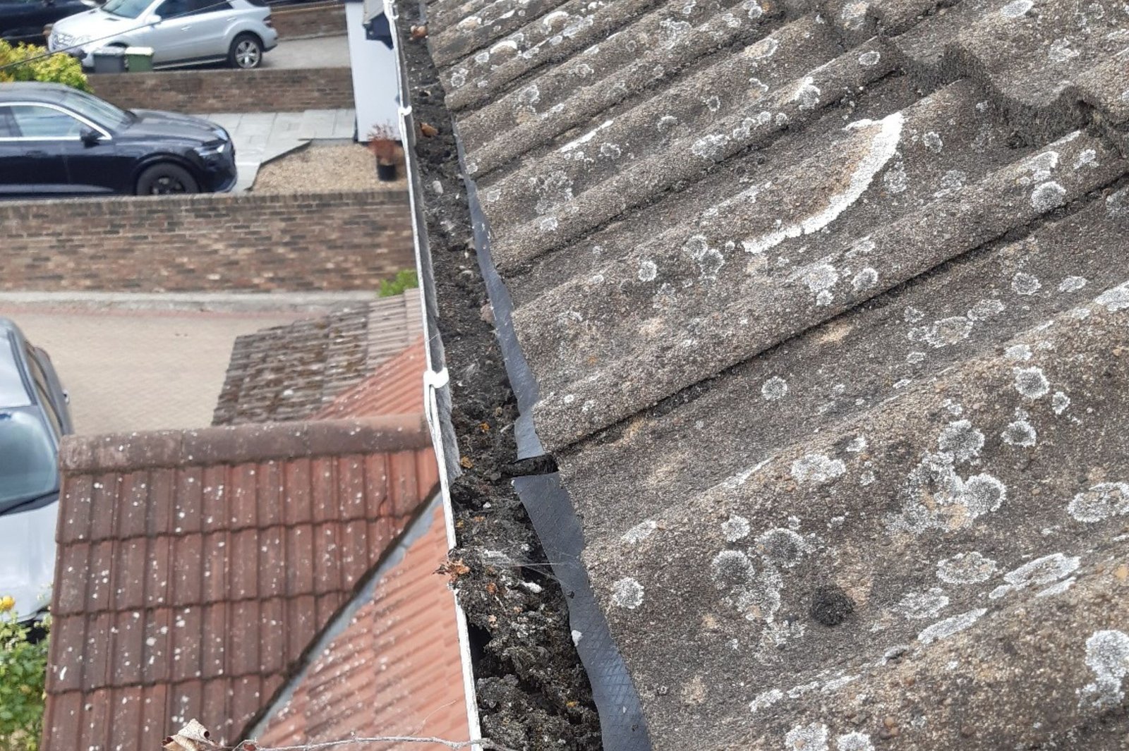Gutter heavily blocked with moss and roof debris before clearance in Rayleigh