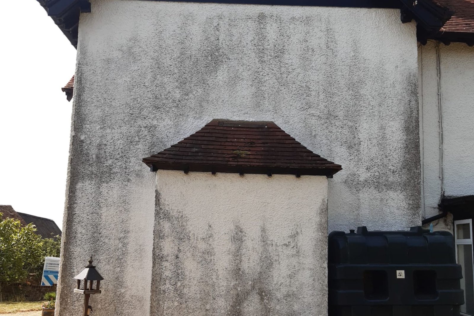 White rendered wall affected by black organic staining before cleaning in Rayleigh